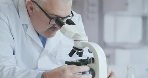 Scientist Using Microscope in Bright Laboratory