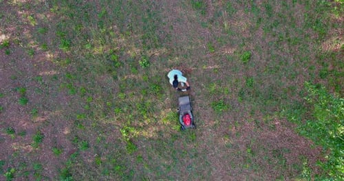 Working Lawn Mower on Green Lawn with Trimmed Grass in Garden Care Work Tool an Aerial View