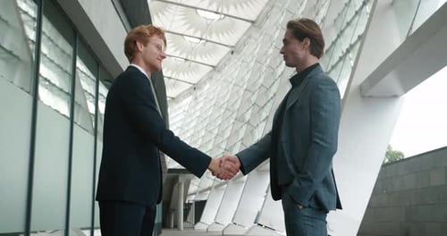 Two businessmen shaking hands in a modern setting