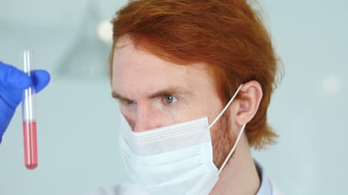 Científico estudia solución roja en tubo de ensayo en laboratorio