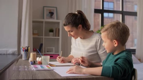 Woman and Child Painting with Watercolors at Home