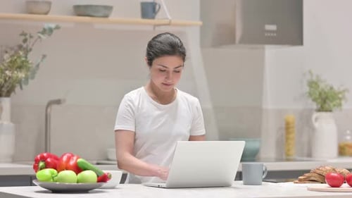 Woman Works on Laptop in Modern Kitchen