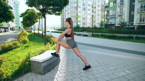 Fitnesswoman Stretching Legs on Bench in City