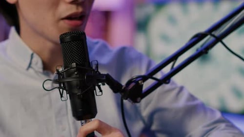 Young Adult Speaking Into a Podcast Microphone
