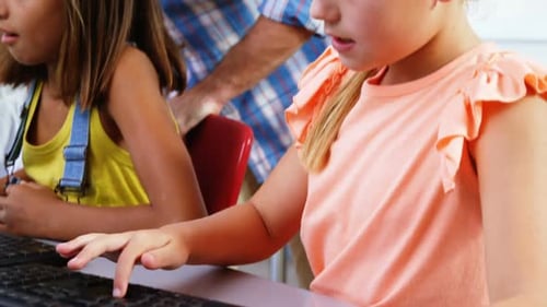 School kids using computer in classroom