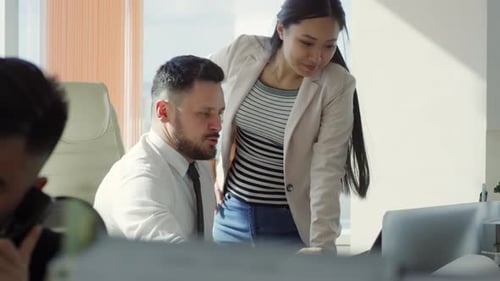 Des collègues multiethniques discutent d'un projet au travail