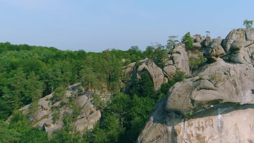 Drone Shot of Rocky Mountainside with Green Trees