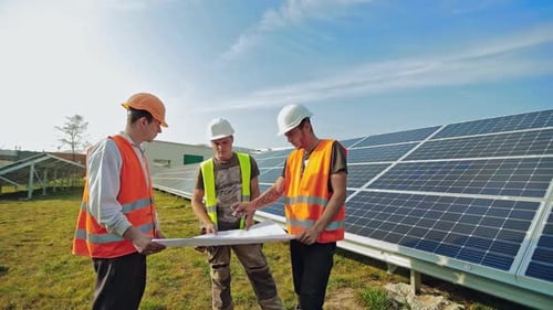 Technicians mounting solar panels. Workers installing alternative energy photovoltaic solar panels