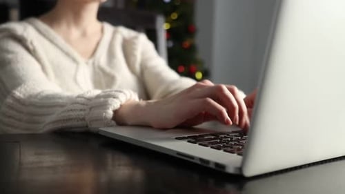 Woman working with laptop computer at home in Christmas time