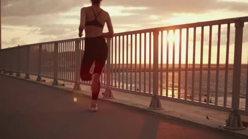 The Athlete Runs Along the Sea Along the Embankment