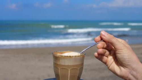 Stirring Coffee Drink on Sunny Beach