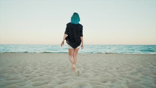 Woman with Unusual Blue Dyed Hair Walking Barefoot on Sandy Beach Alone. Slow Motion. Girl Walks