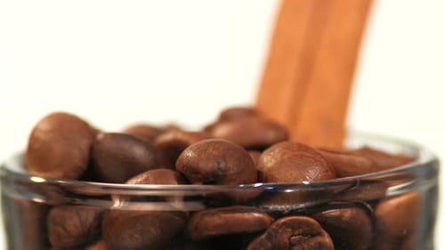 Top of Little Bottle with Brown Coffee Beans and Cinnamon Close Up