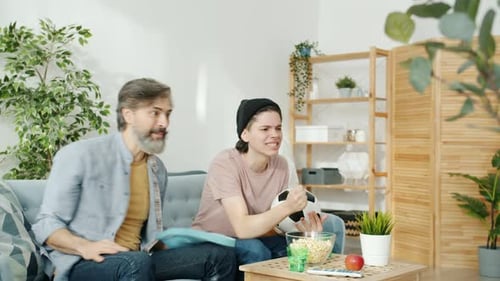 Father and Son Cheering at Soccer Game at Home