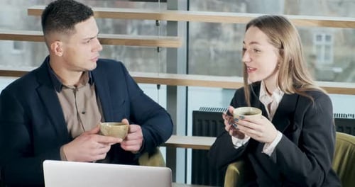 Mann und Frau diskutieren über Arbeit im hell erleuchteten modernen Büro. Mann und Frau arbeiten mit