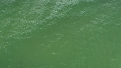 Rotating Shot of Waves Crashing on the Surface of Green Sea
