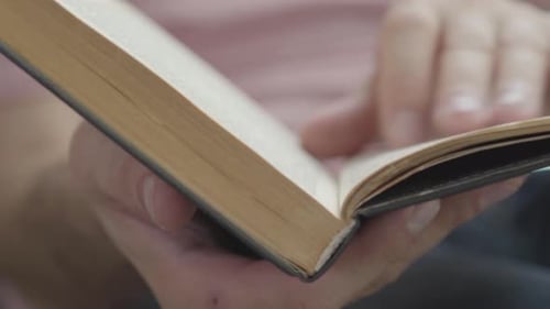 Close-up of Male Hands Leafing Through the Pages of the Book Indoors. Concept of Knowledge