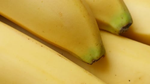 Yellow banana fruit pieces arranged in a row 4K 2160p 30fps UltraHD tilt footage - Musa acuminata a