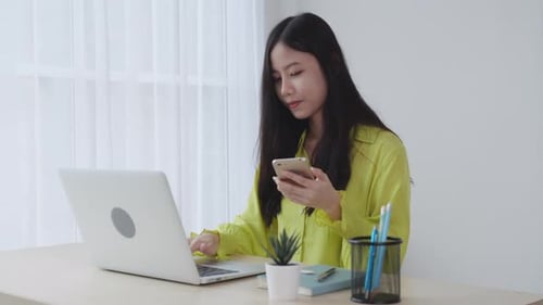 Young asian businesswoman working on laptop computer online on desk at home office.