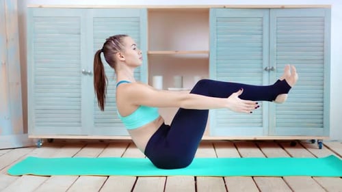 Young Woman Exercises Core Strength on Yoga Mat