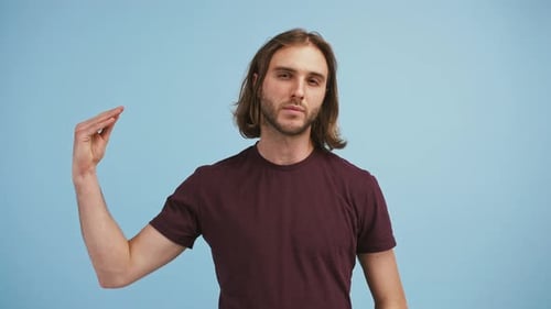 Der junge Mann sieht enttäuscht aus und zeigt Blahblah Handgeste auf blauem Hintergrund