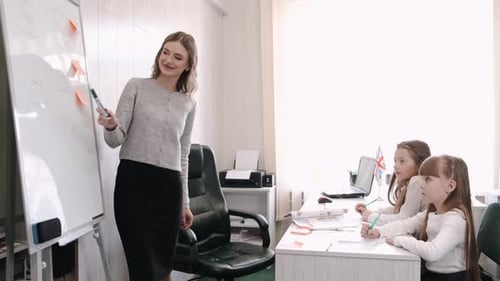 Dedicated Teacher Explains Lesson to Young Students
