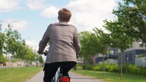 Young Man Riding Bicycle on City Street