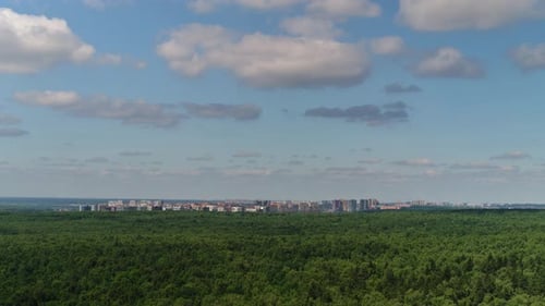 Wolken über dem Wald und der Stadt