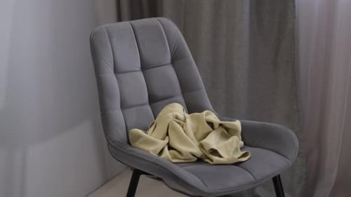 Pile of Clothes on a Gray Upholstered Chair