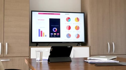 Revealing Shot Company Sales Report on Big Screen Plasma TV in Meeting Room