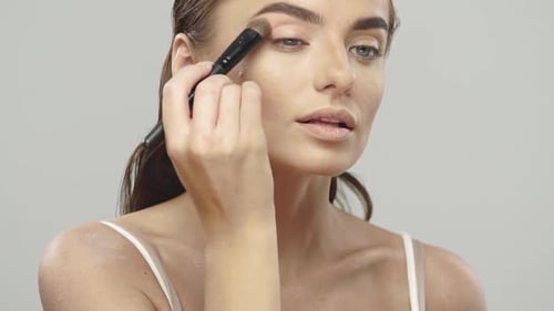 Young Woman Applies Makeup in Beauty Tutorial