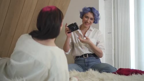 Stylish Young Women Photographing on Bed Indoors