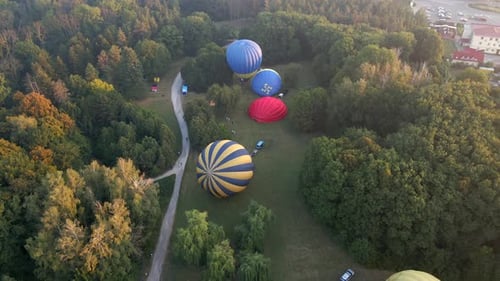 Aerial View of Hot Air Balloons Prepare for an Summer Early Morning Flying in Park in Small European