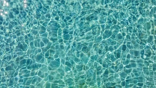 Textur der Wasseroberfläche, Schleife, saubere Wellen und Wellen des Schwimmbades, Brechung des Sonnenlichts, Ansicht von oben