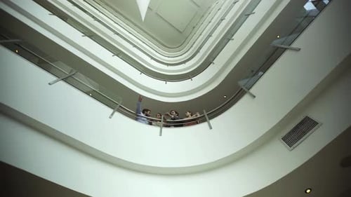 Businessman looking at building atrium with clients