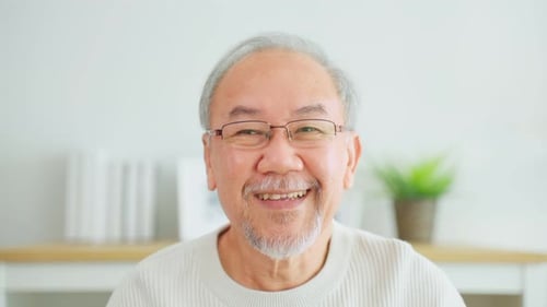 Senior Man Smiling Directly at Camera in Bright Room