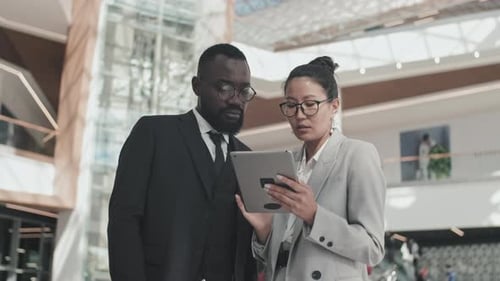 Business Team Examining Tablet in Modern Office