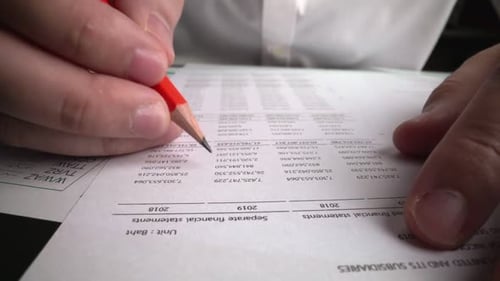 Accountant Analyzing Business Marketing Data on Paper Dashboard at Office Table