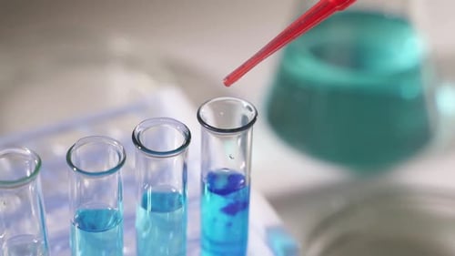 Dropping Red Liquid into Test Tube in Lab