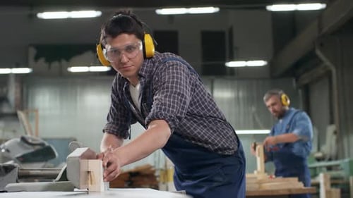 Men Cutting Wood in an Industrial Workshop