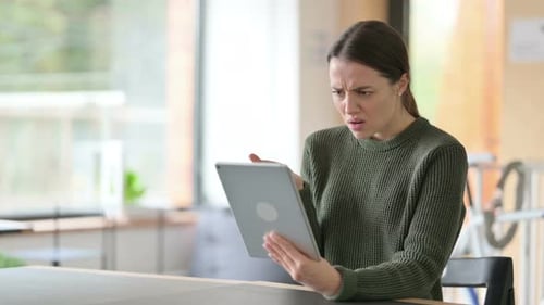 Woman Looking at Tablet with Confused Expression