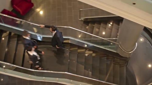 Professionals Walking Down Modern Office Building Staircase