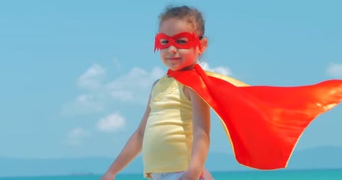 Child Posing on Beach with Superhero Costume