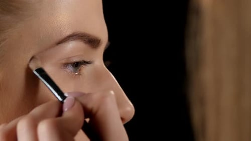 Applying Eyebrow Brush. Makeup. Black. Closeup