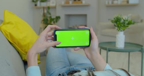 TOUCHE CHROMA SUR ÉCRAN VERT. Femme caucasienne utilisant un téléphone intelligent générique, orientation horizontale, moderne
