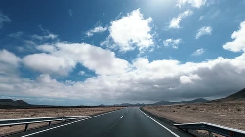 Dramatic sky landscape with long straight road and fast moving movement from car or van vehicle.