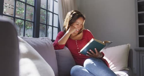 Mixed race woman reading a book. Social distancing and self isolation in quarantine