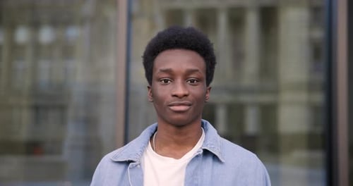 Smiling Young Man Standing in Front of Building