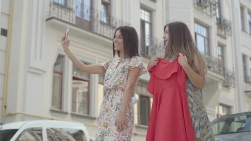 Young Women Pose for Selfie with a Dress