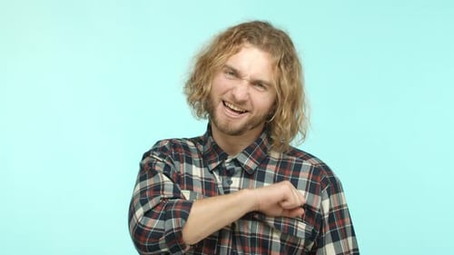 Young Adult Threatens, Smiles, Light Blue Background